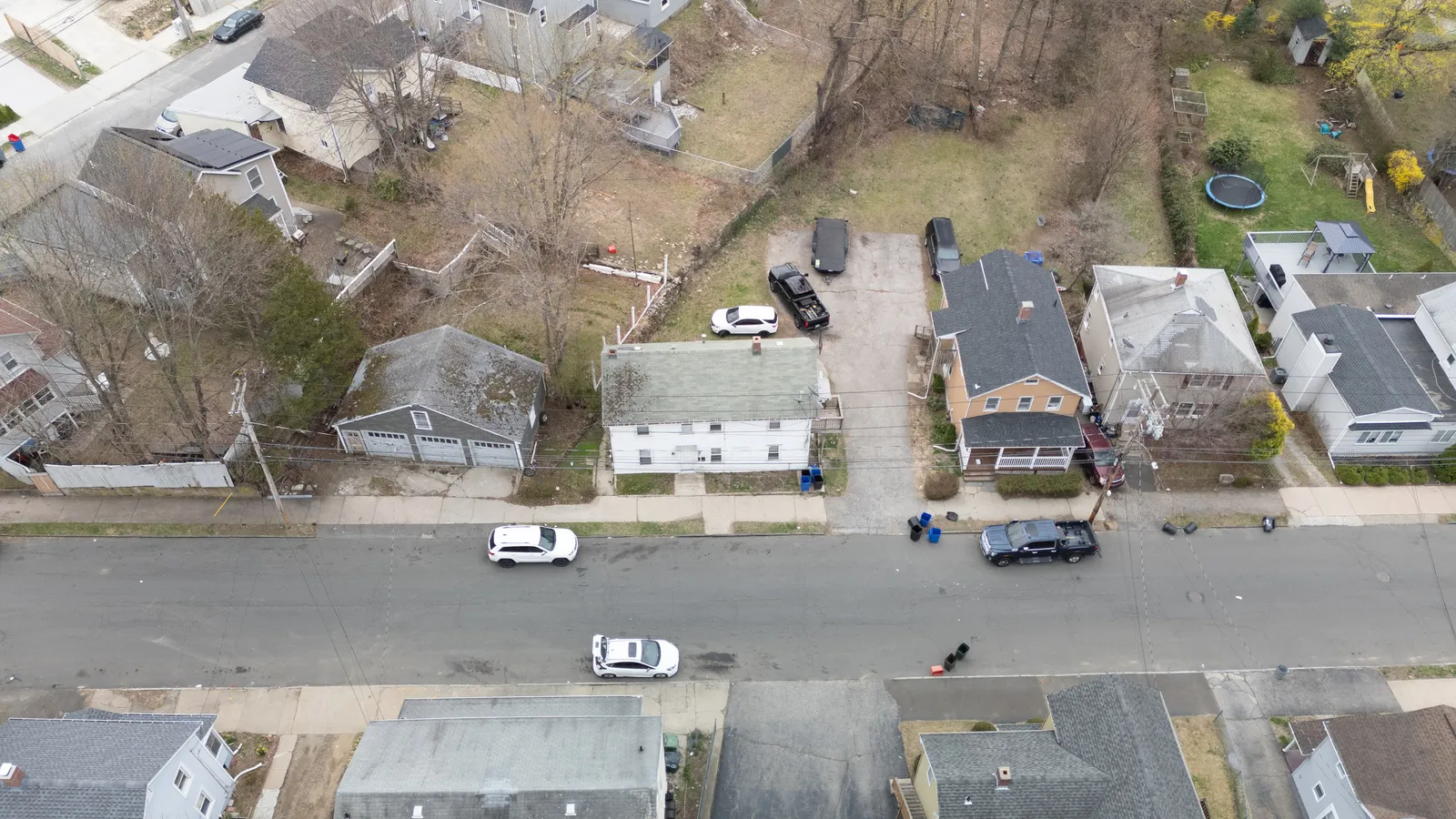 Overhead drone view of a single-family home and its lot, capturing the property and surrounding street from directly above