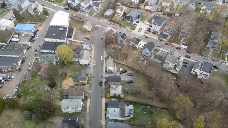 Aerial view of a residential neighborhood showing the street grid, rooftops, and tree-lined blocks from above